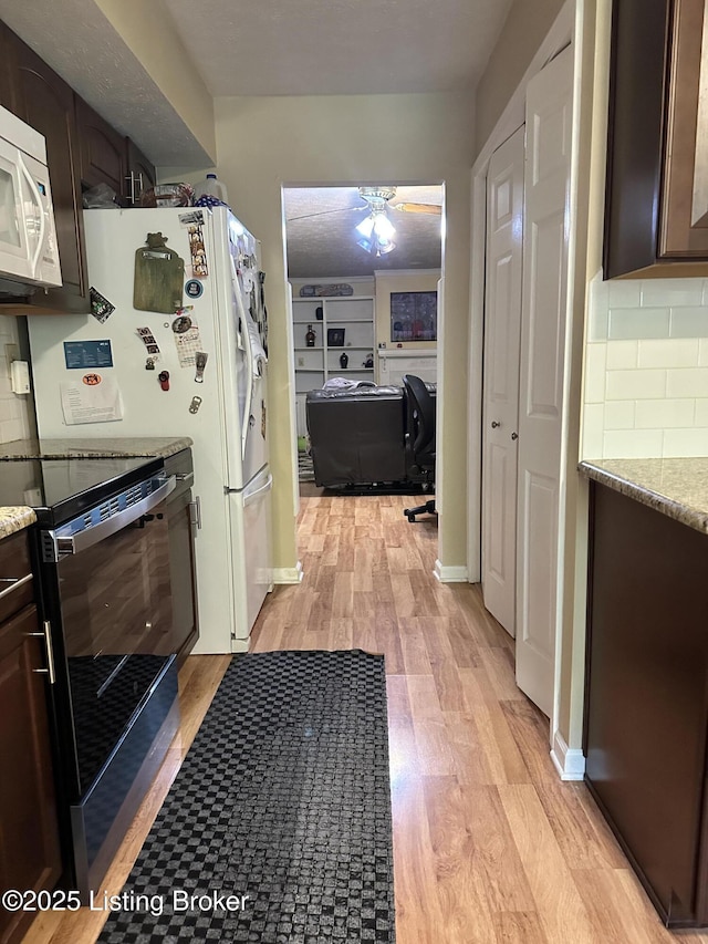 509 Piping Rock Rd, Brandenburg, KY 40108 - kitchen featuring stainless steel range with electric cooktop, white microwave, dark brown cabinetry, light wood-style floors, and tasteful backsplash
