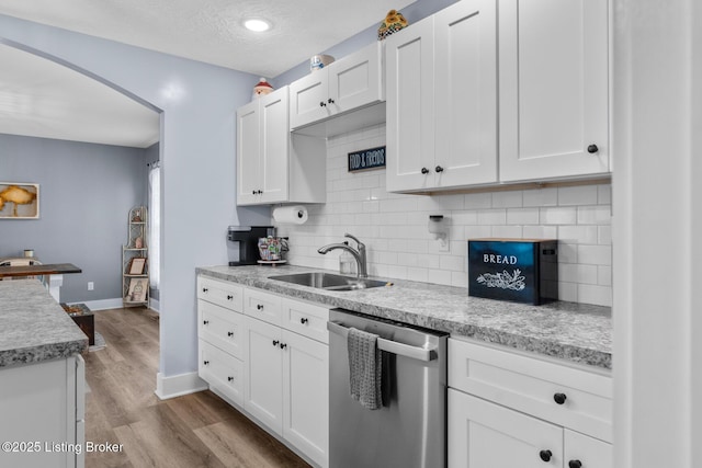 63 Davis Norton Ln, Harned, KY 40144 - kitchen with dishwasher, light countertops, tasteful backsplash, light wood-type flooring, and a textured ceiling
