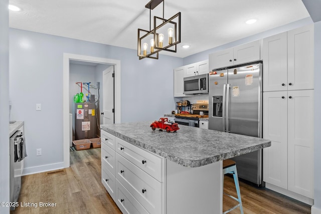 63 Davis Norton Ln, Harned, KY 40144 - kitchen featuring stainless steel appliances, wood finished floors, white cabinets, a center island, and recessed lighting