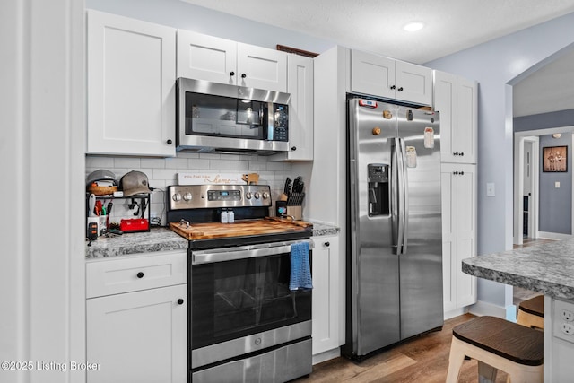 63 Davis Norton Ln, Harned, KY 40144 - kitchen with stainless steel appliances, backsplash, wood finished floors, light countertops, and white cabinetry