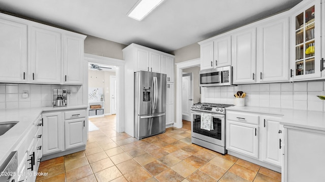 1910 Alfresco Pl, Louisville, KY 40205 - kitchen with appliances with stainless steel finishes, white cabinets, light countertops, glass insert cabinets, and backsplash