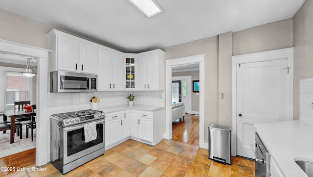 1910 Alfresco Pl, Louisville, KY 40205 - kitchen featuring appliances with stainless steel finishes, light countertops, backsplash, and white cabinetry