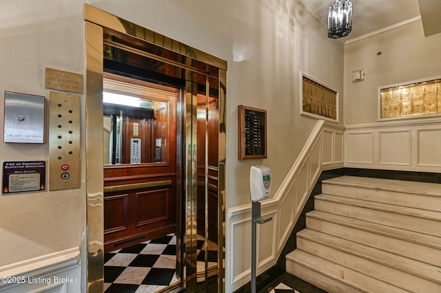 1416 Willow Ave Unit 3B, Louisville, KY 40204 - staircase featuring a decorative wall, elevator, a wainscoted wall, ornamental molding, and a chandelier