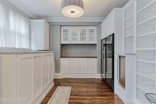 1416 Willow Ave Unit 3B, Louisville, KY 40204 - kitchen with white cabinetry, dark wood finished floors, light stone countertops, crown molding, and glass insert cabinets