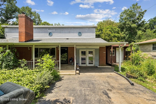 363 S Deepwood Dr, Radcliff, KY 40160 - view of front of house featuring french doors, brick siding, a chimney, a porch, and a shingled roof