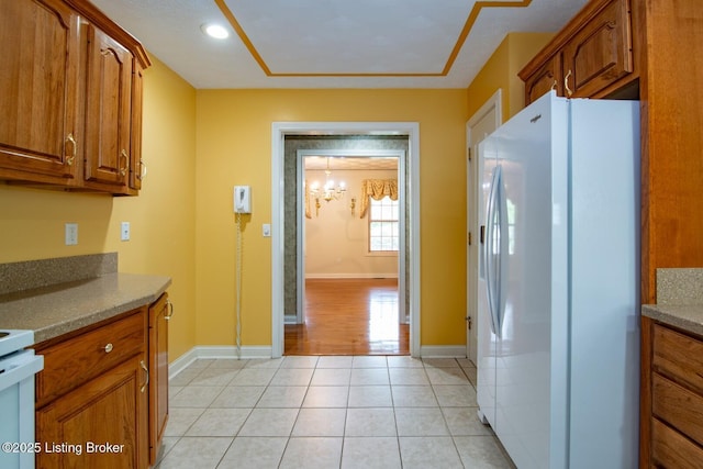 236 Bobwhite Rd, Brandenburg, KY 40108 - kitchen featuring freestanding refrigerator, brown cabinets, light tile patterned floors, and recessed lighting