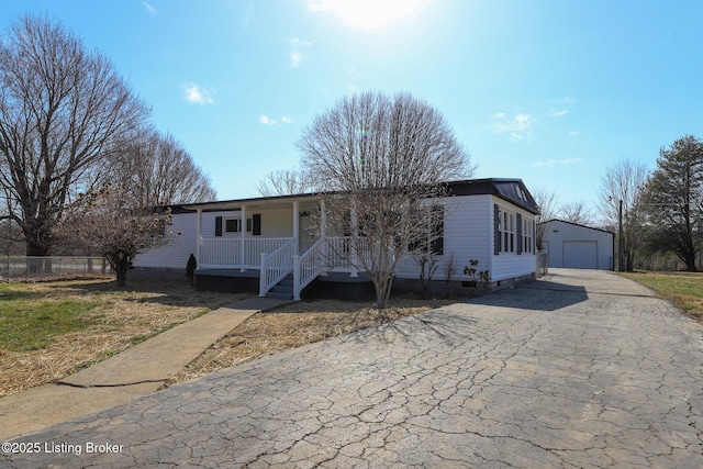 43 Mcfarlin Ln, Vine Grove, KY 40175 - view of front of property featuring a porch, driveway, a garage, and an outbuilding