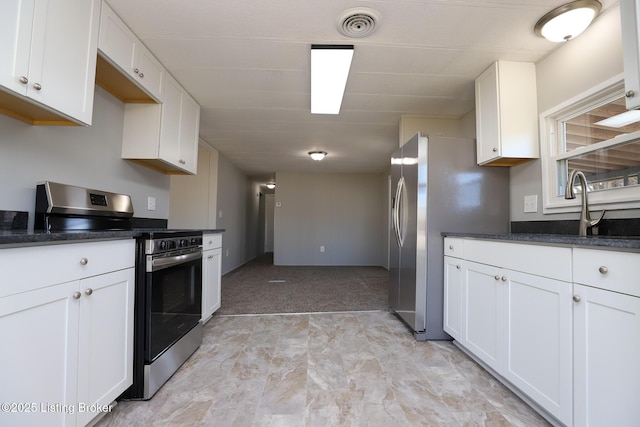 43 Mcfarlin Ln, Vine Grove, KY 40175 - kitchen with stainless steel appliances, white cabinetry, dark stone counters, and light colored carpet