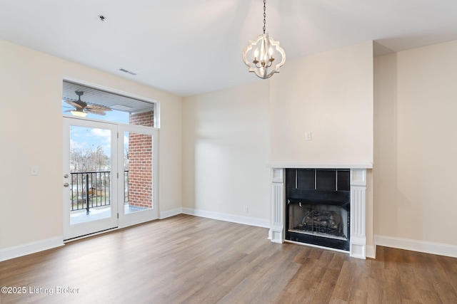 2011 Frankfort Ave Unit Unit312, Louisville, KY 40206 - unfurnished living room with wood finished floors, a chandelier, a fireplace, and a ceiling fan