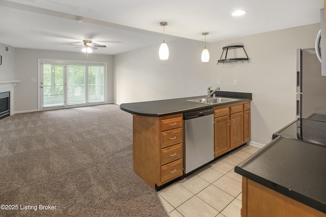 2726 Hollywood Ter Apt 101, Louisville, KY 40206 - kitchen with appliances with stainless steel finishes, a peninsula, brown cabinetry, ceiling fan, and dark countertops