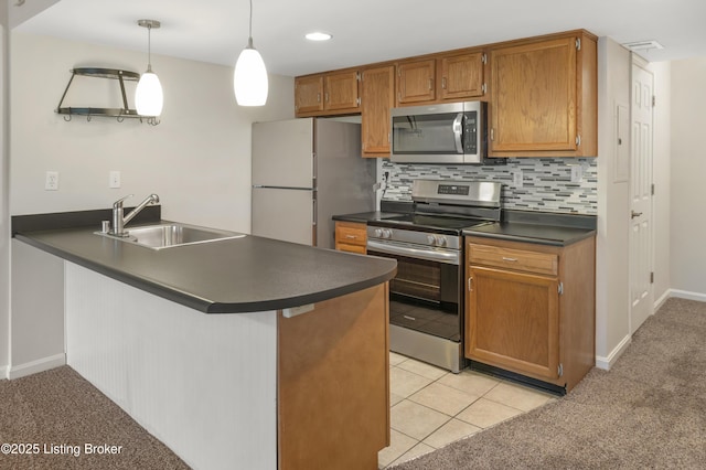 2726 Hollywood Ter Apt 101, Louisville, KY 40206 - kitchen featuring stainless steel appliances, dark countertops, a peninsula, decorative backsplash, and light colored carpet