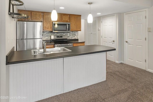 2726 Hollywood Ter Apt 101, Louisville, KY 40206 - kitchen with stainless steel appliances, dark countertops, hanging light fixtures, brown cabinets, and recessed lighting
