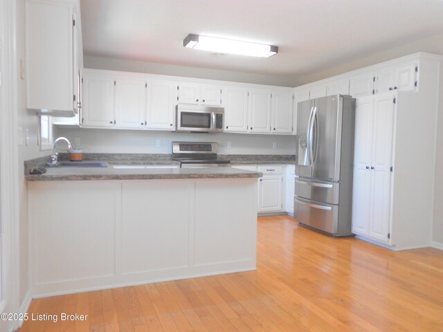 732 Poplar Flat Rd, Bardstown, KY 40004 - kitchen with appliances with stainless steel finishes, a peninsula, light wood-style floors, and white cabinetry