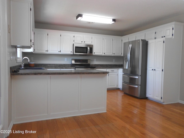 732 Poplar Flat Rd, Bardstown, KY 40004 - kitchen featuring a peninsula, stainless steel appliances, light wood-type flooring, and white cabinetry