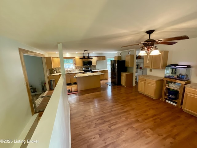 40 Sunflower Ln, Brandenburg, KY 40108 - kitchen featuring black appliances, a kitchen island, wood finished floors, tasteful backsplash, and ceiling fan
