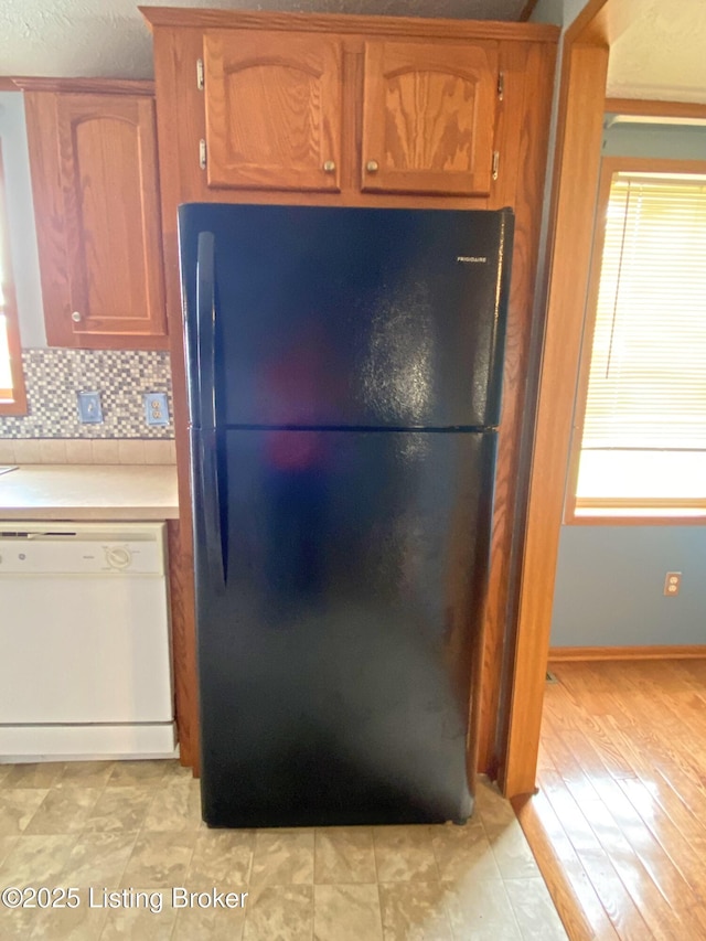 356 Armes Lively Rd, Leitchfield, KY 42754 - kitchen featuring freestanding refrigerator, dishwasher, light countertops, brown cabinets, and backsplash