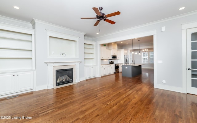 9403 Delphinium St Unit 101, Prospect, KY 40059 - unfurnished living room featuring ornamental molding, ceiling fan, dark wood-style flooring, a high end fireplace, and built in shelves