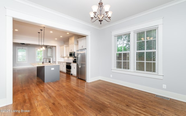 9403 Delphinium St Unit 101, Prospect, KY 40059 - kitchen with crown molding, appliances with stainless steel finishes, light countertops, a chandelier, and an island with sink