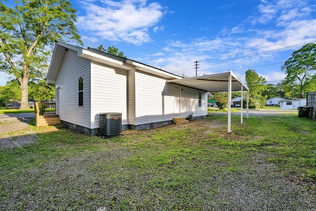 view of side of property with a lawn and central AC