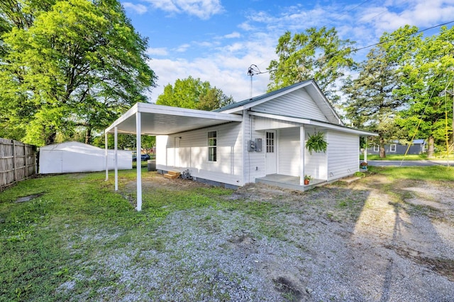 back of house with a yard, driveway, an attached carport, and fence