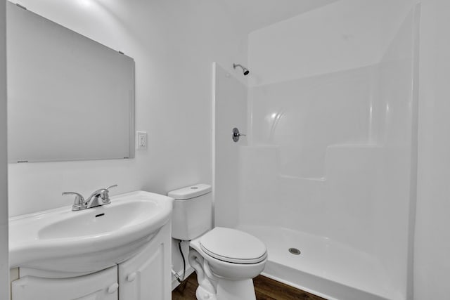 full bathroom with toilet, wood finished floors, a shower stall, and vanity