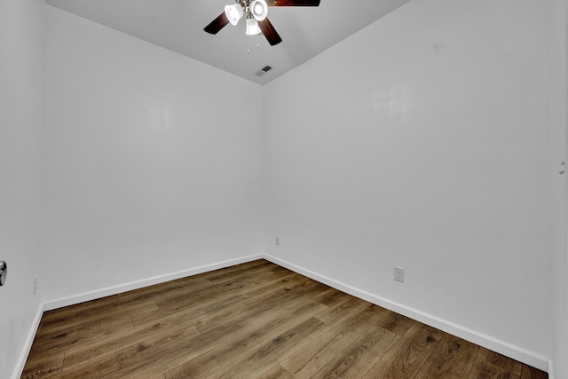 unfurnished room with a ceiling fan, visible vents, baseboards, and wood finished floors