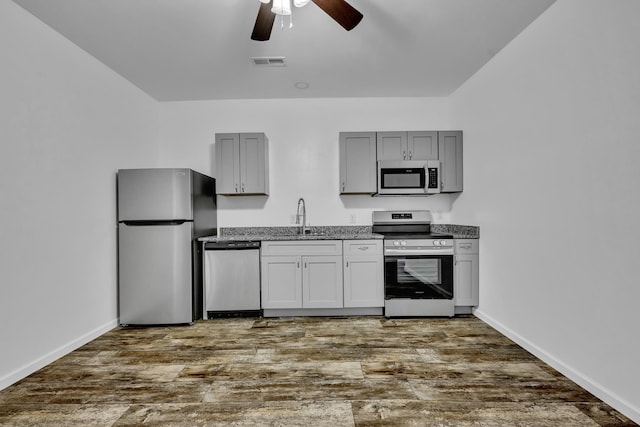 kitchen with a sink, visible vents, stainless steel appliances, and dark wood finished floors