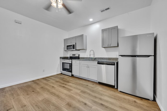 kitchen with ceiling fan, light wood-style flooring, a sink, visible vents, and appliances with stainless steel finishes