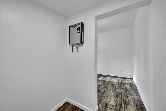corridor featuring baseboards and dark wood-type flooring