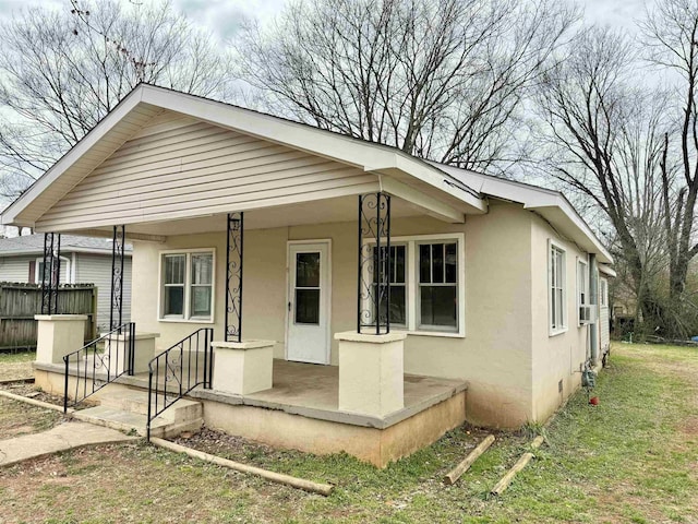 view of front of home featuring a porch, cooling unit, and stucco siding