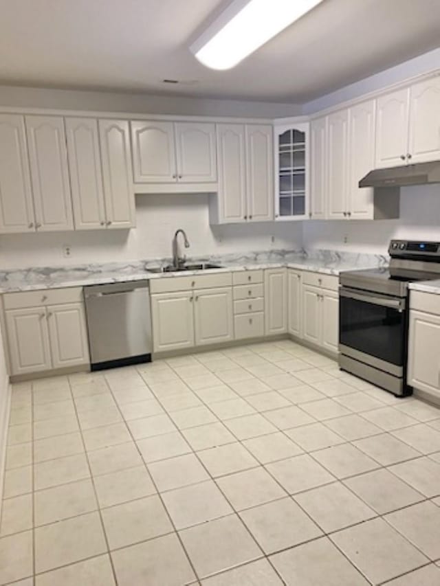 kitchen featuring white cabinets, appliances with stainless steel finishes, sink, and light tile patterned flooring