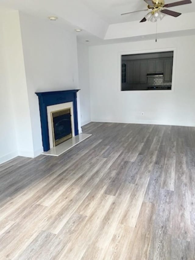 unfurnished living room featuring wood-type flooring and ceiling fan