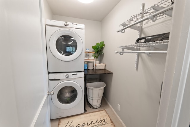 - laundry area featuring stacked washing machine and dryer and baseboards