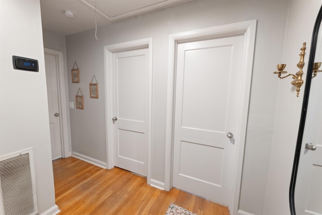  - corridor with attic access and light wood-style floors