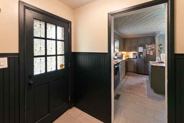  - entryway featuring a wainscoted wall and a sink