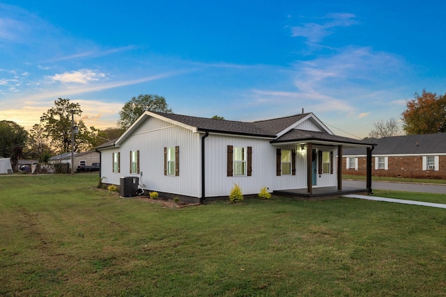 view of front facade featuring a lawn, cooling unit, and a porch