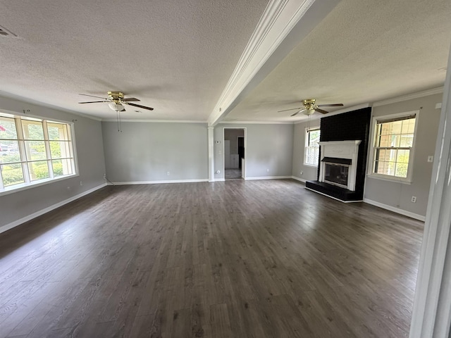  - unfurnished living room featuring a ceiling fan, a textured ceiling, crown molding, plenty of natural light, and a glass covered fireplace