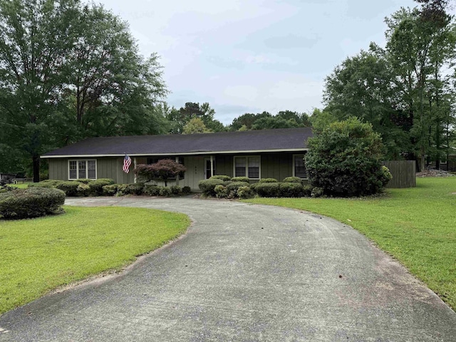 - single story home with curved driveway, a front yard, and board and batten siding