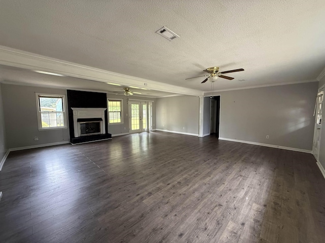  - unfurnished living room with ceiling fan, a textured ceiling, crown molding, dark wood-style floors, and a fireplace with raised hearth