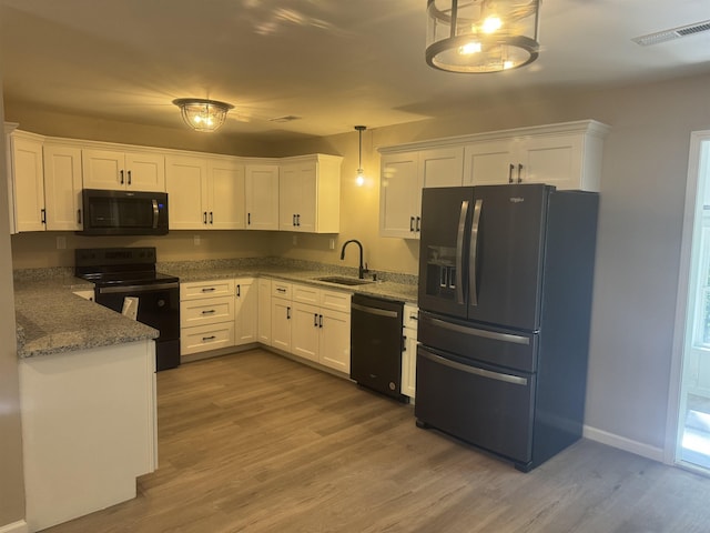 kitchen with black appliances, sink, decorative light fixtures, white cabinetry, and wood-type flooring