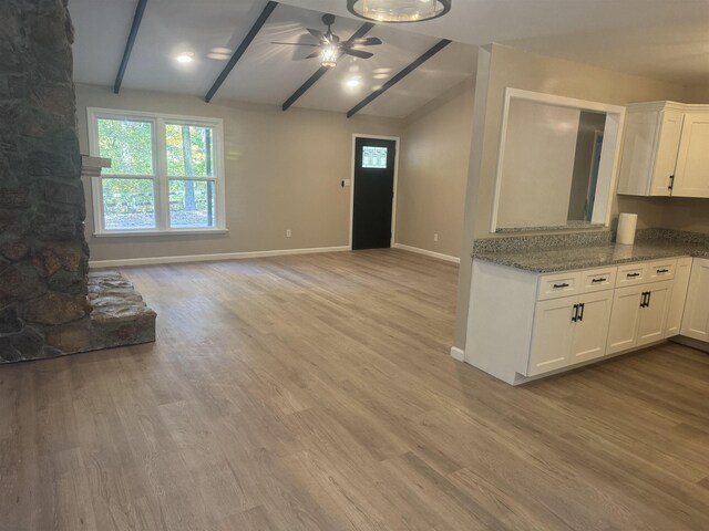 unfurnished living room featuring lofted ceiling with beams, ceiling fan, and light wood-type flooring