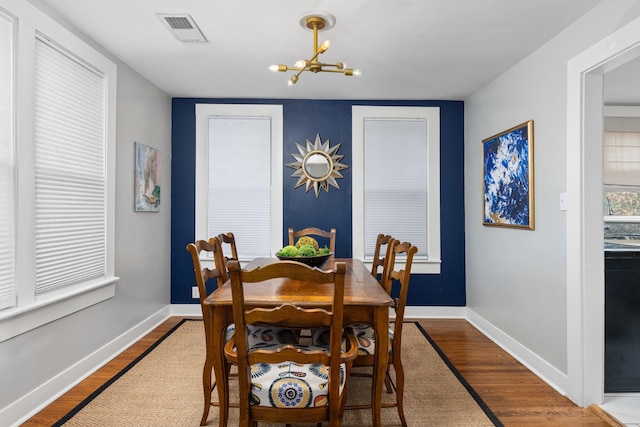 dining room with hardwood / wood-style flooring and a notable chandelier