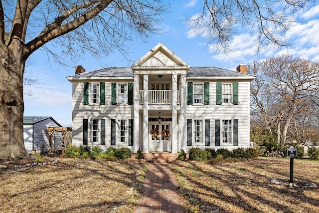 greek revival house with french doors and a balcony