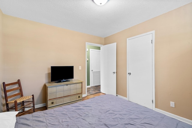  - bedroom featuring baseboards and a textured ceiling