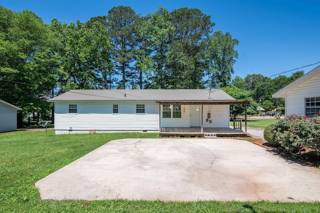  - back of property featuring a yard, metal roof, and crawl space