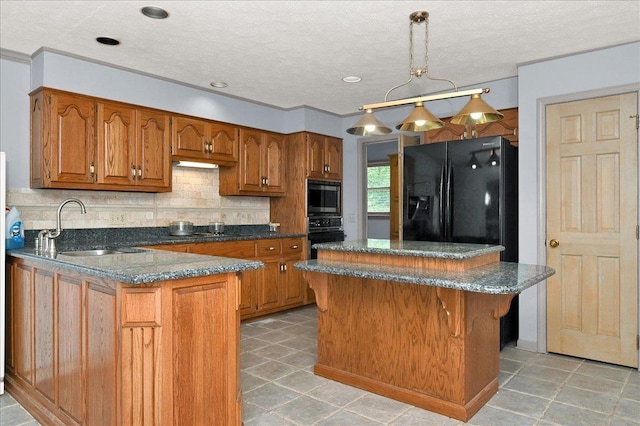 kitchen featuring pendant lighting, sink, a kitchen island, and black appliances