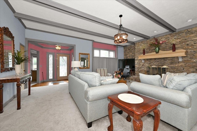 carpeted living room featuring beamed ceiling, a fireplace, and a notable chandelier