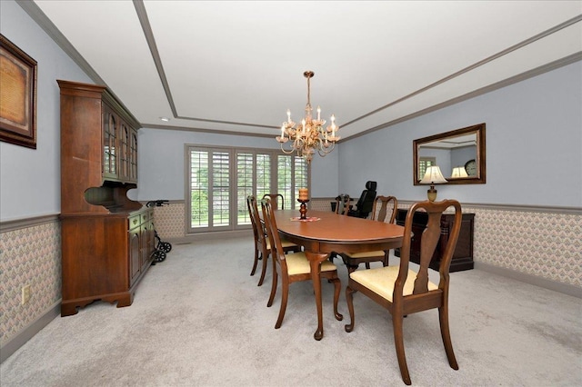 dining area with a notable chandelier, light colored carpet, and ornamental molding