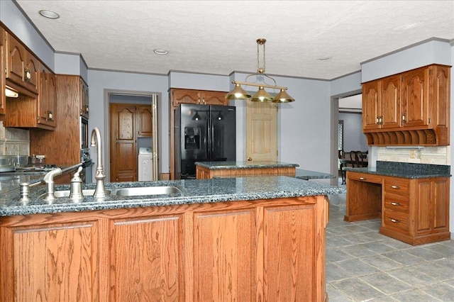 kitchen with decorative backsplash, black fridge, hanging light fixtures, and a textured ceiling