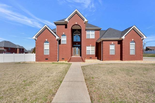 traditional home featuring brick siding, a shingled roof, crawl space, fence, and a front lawn